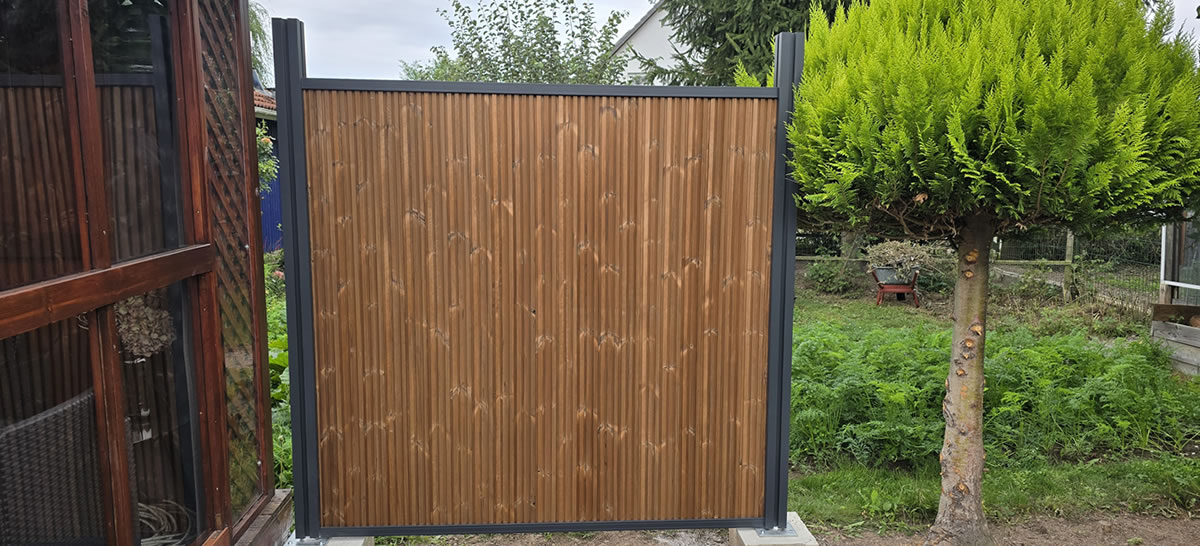 Sichtschutzzaun aus Holz mit grau gestrichenem Metallrahmen - Handwerker Robert Schäke aus Bad Pyrmont, ihr Allround Handwerkerservice für Dienstleistungen in Haus und Garten um Hameln und Bad Pyrmont, Handwerker Allrounder für Renovierung, Modernisierung, Sanierung im Raum Hameln Pyrmont. Wasserschadensanierung und Kaminsanierung durch den Handwerkerservice Robert Schäke. Frei stehender Sichtschutzzaun - Allround Handwerker in Hameln und Bad Pyrmont - Handwerkerservice Robert Schäke für Renovierung, Modernisierung, Sanierung, Dienstleistungen für Haus und Garten